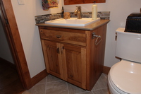Thumb vanity  rustic style  knotty hickory  medium color  raised panel  single sink  standard overlay