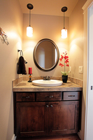 Thumb vanity  shaker style  knotty alder  dark color  rrecessed panel  two small drawers above two wide doors  standard overlay