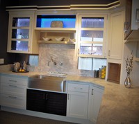 Thumb kitchen  contemporary style  painted with accent color walnut  recessed panel and savannah doors  glass doors  lighted glass back  open shelf  apron front sink  bank of drawers  taller toekick  hybrid construction   1 