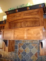 Thumb kitchen  craftsman style  knotty alder  raised and recessed panel  medium color with accent crown blocks on  7 crown  custom wood hood