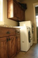 Thumb laundry or utility  traditional style  knotty alder  dark color  raised panel  1 edge  full overlay  upper above staggered height washer dryer  full overlay